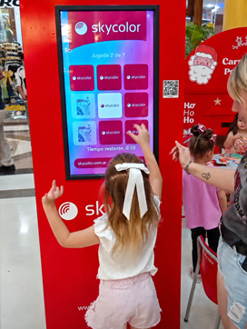 Una niña juega una trivia de Skycolor en un tótem digital PlayGo